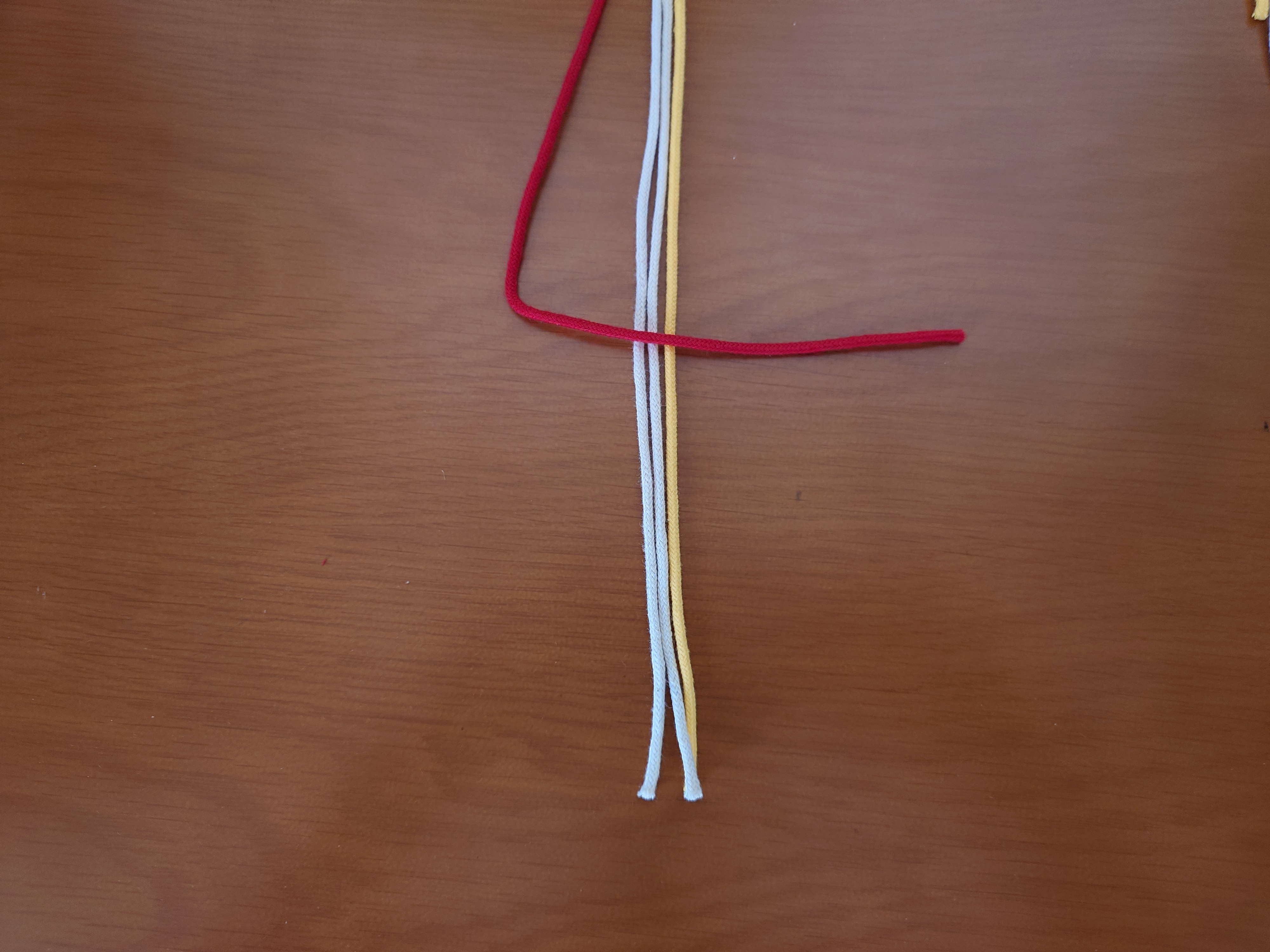 左端の紐を三角に置く