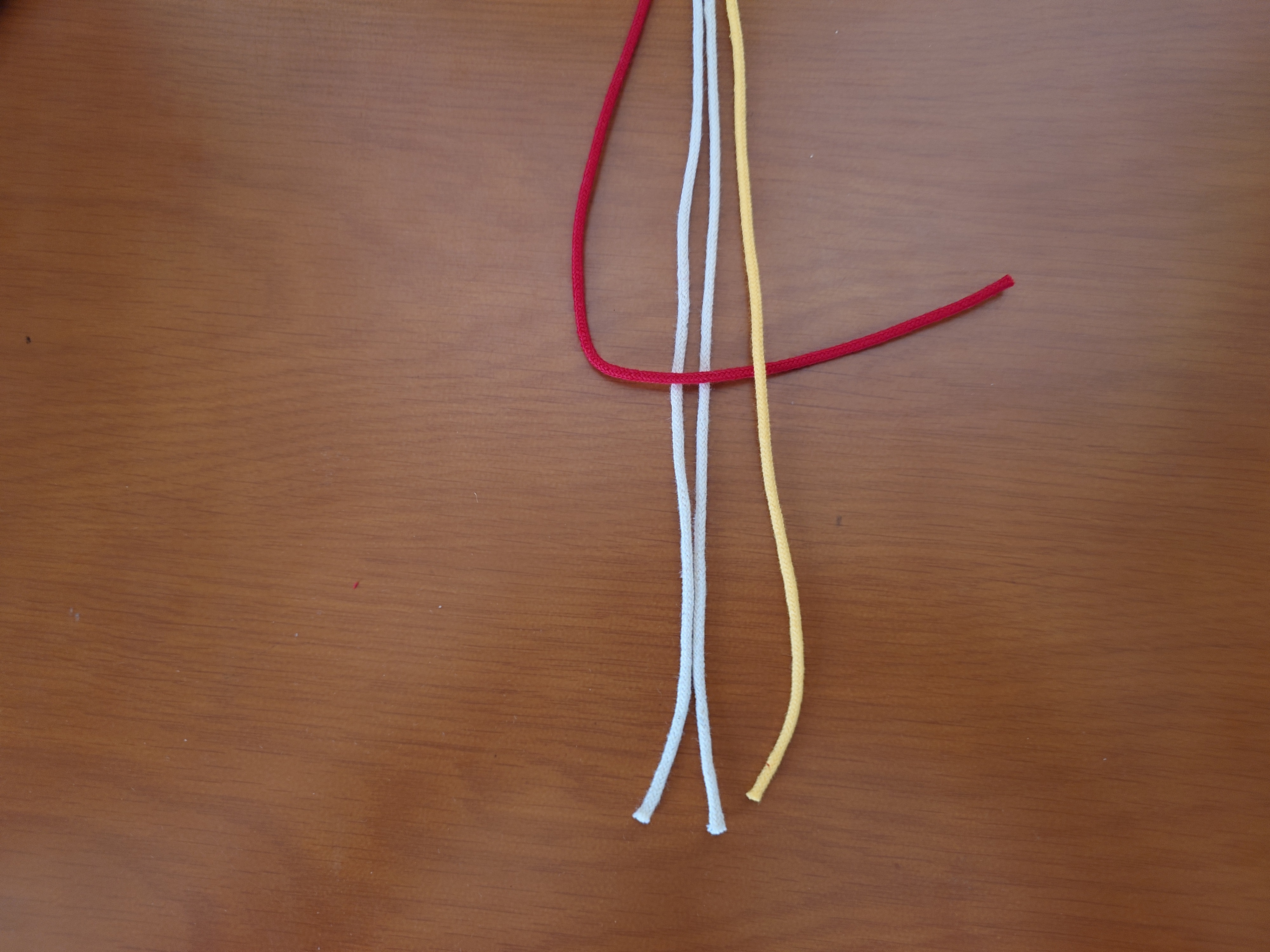 右端の紐をその上に置く