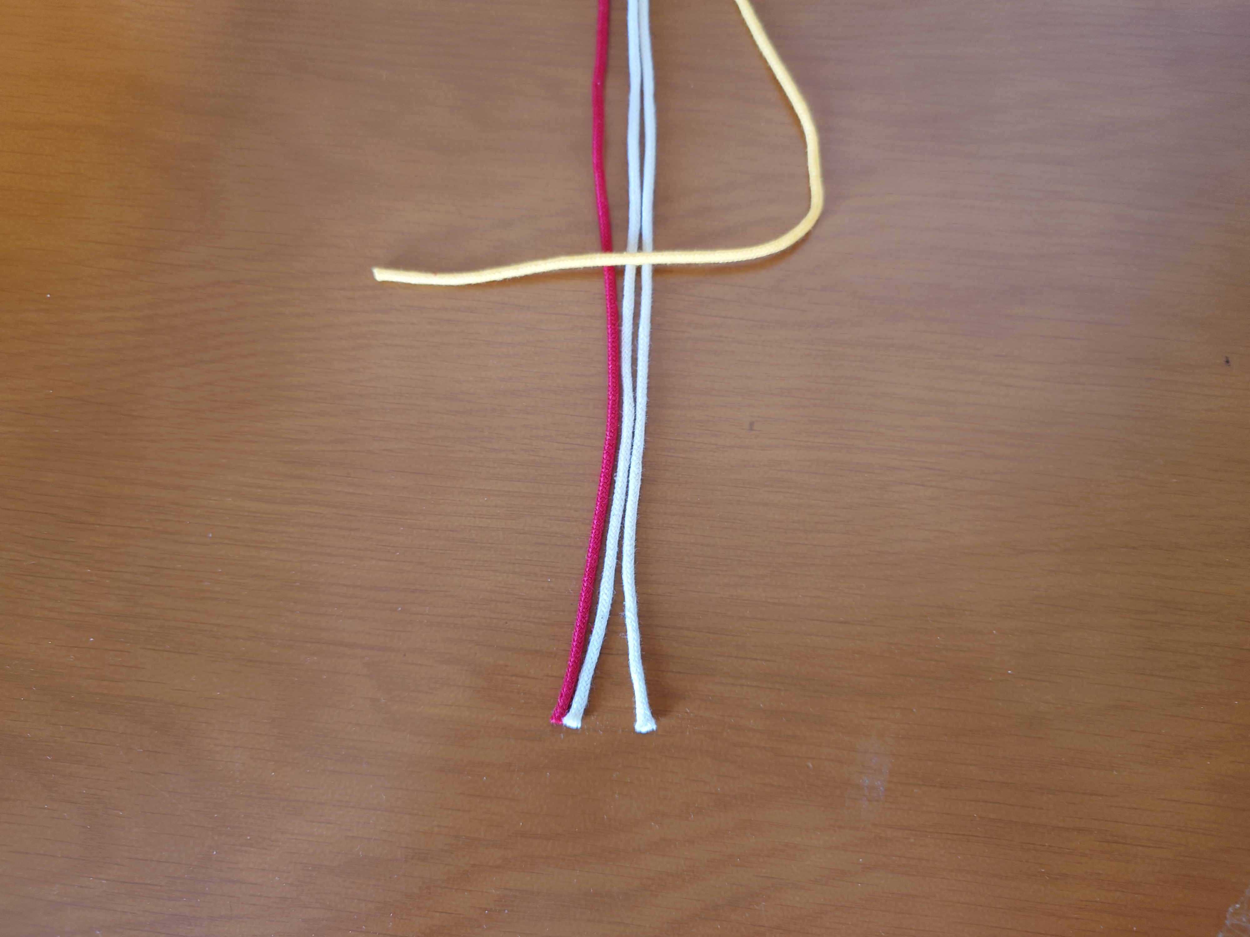 右端の紐を三角に置く