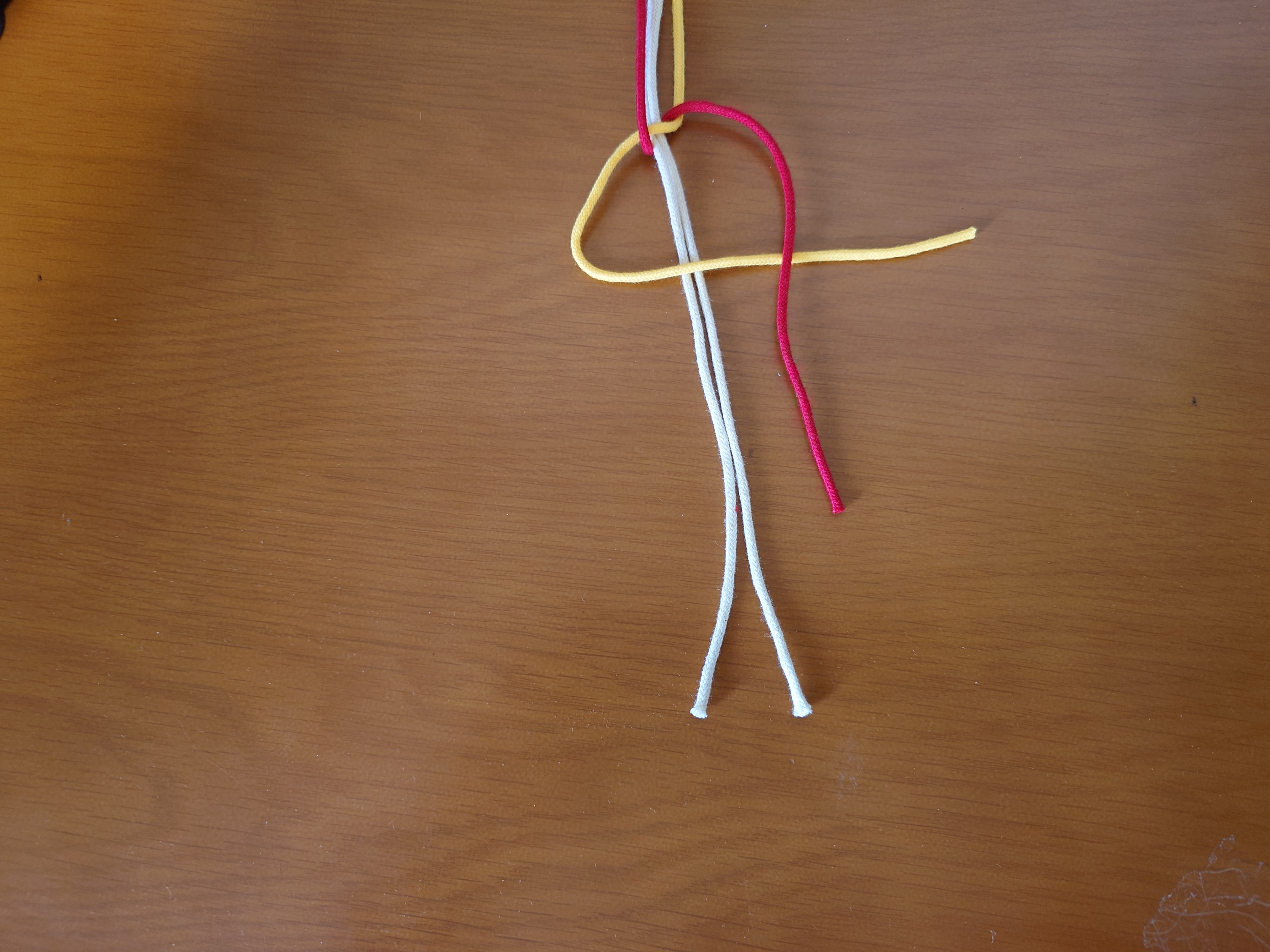 右端の紐をその上に置く